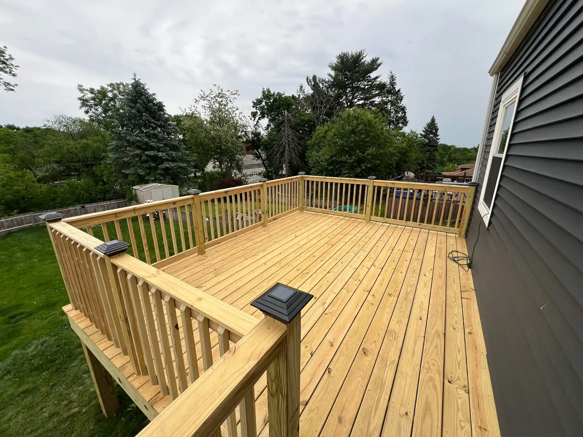 Wooden deck addition on a backyard home progress
