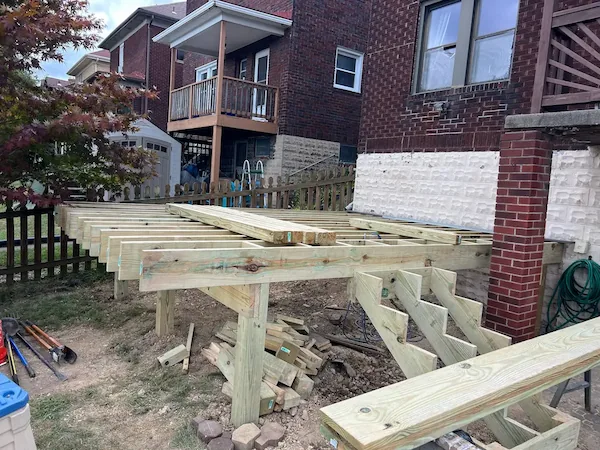 Wooden deck addition on a backyard home progress
